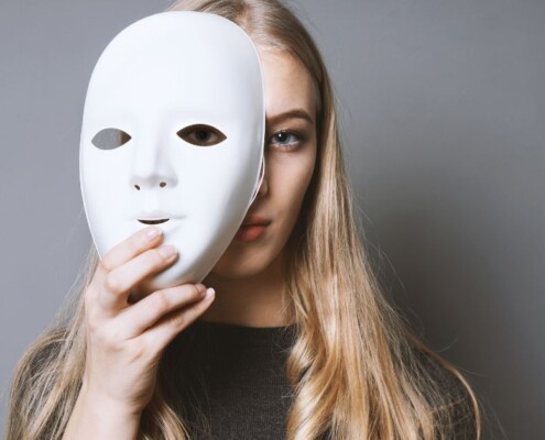 masking woman standing behind white mask